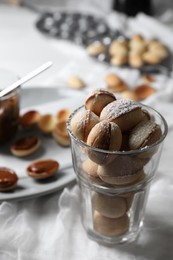 Delicious walnut shaped cookies with condensed milk on table, closeup