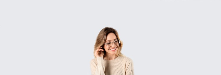 Portrait of happy young woman with beautiful blonde hair and charming smile on light background. Horizontal banner design