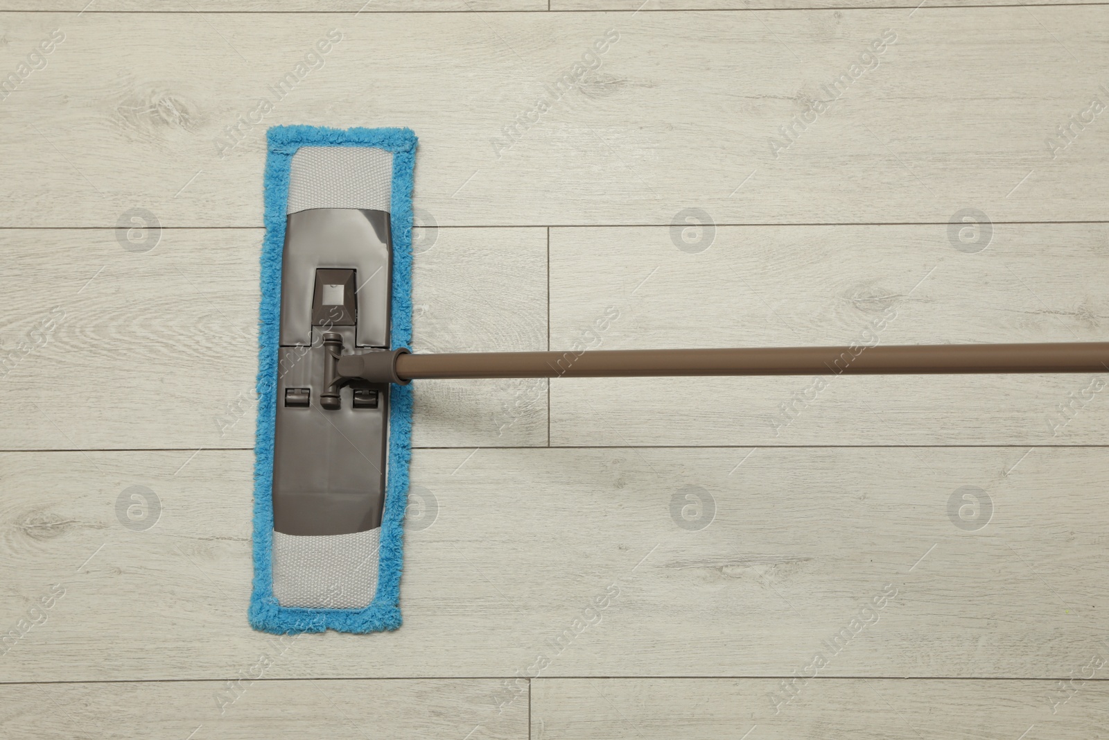 Photo of Cleaning of wooden floor with mop, top view