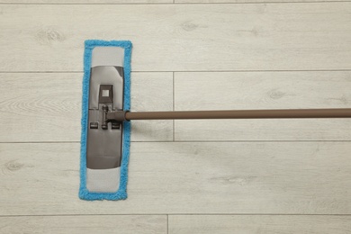 Photo of Cleaning of wooden floor with mop, top view