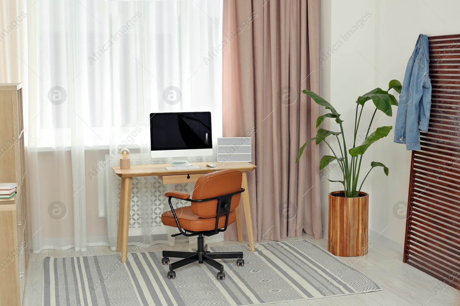 Photo of Stylish teenager's room interior with workplace and beautiful houseplant