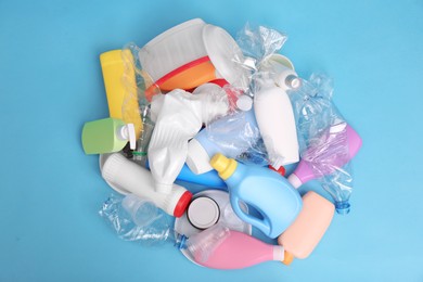 Photo of Pile of plastic garbage on light blue background, flat lay