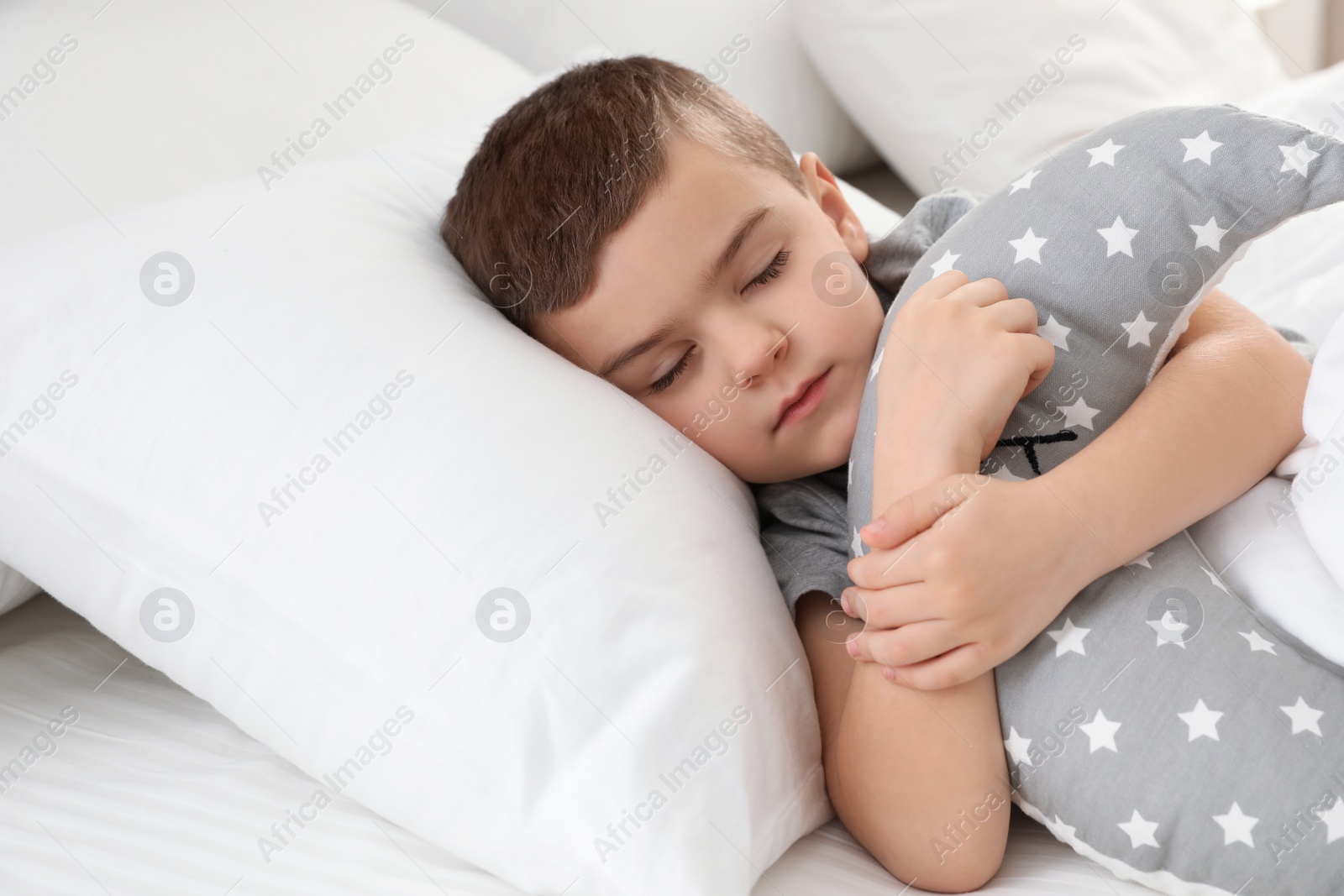 Photo of Cute boy with toy sleeping in bed