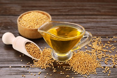 Photo of Jug of natural oil and mustard seeds on wooden table