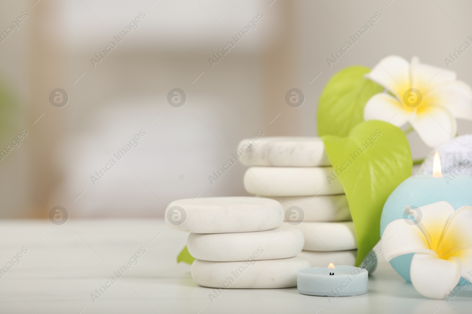 Photo of Composition with different spa products and plumeria flowers on white table, space for text