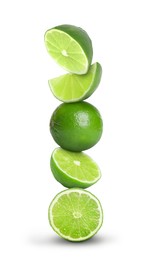 Image of Stacked whole and cut limes on white background