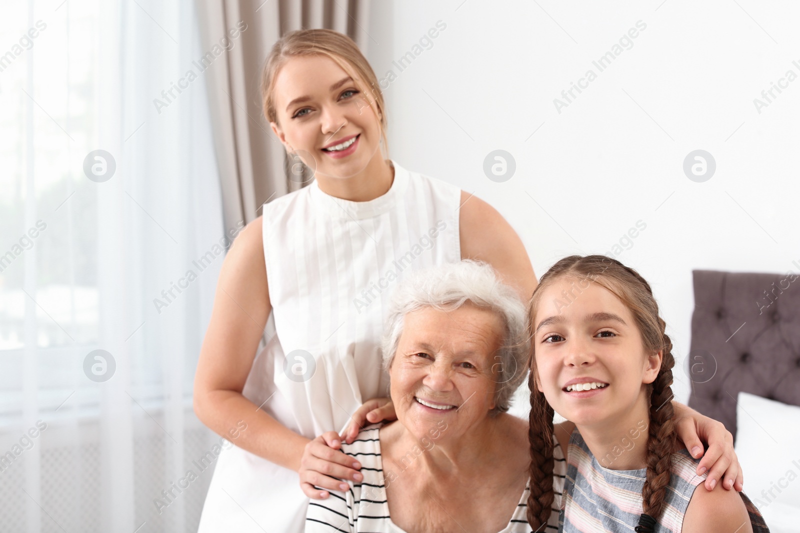 Photo of Happy sisters and their grandmother at home