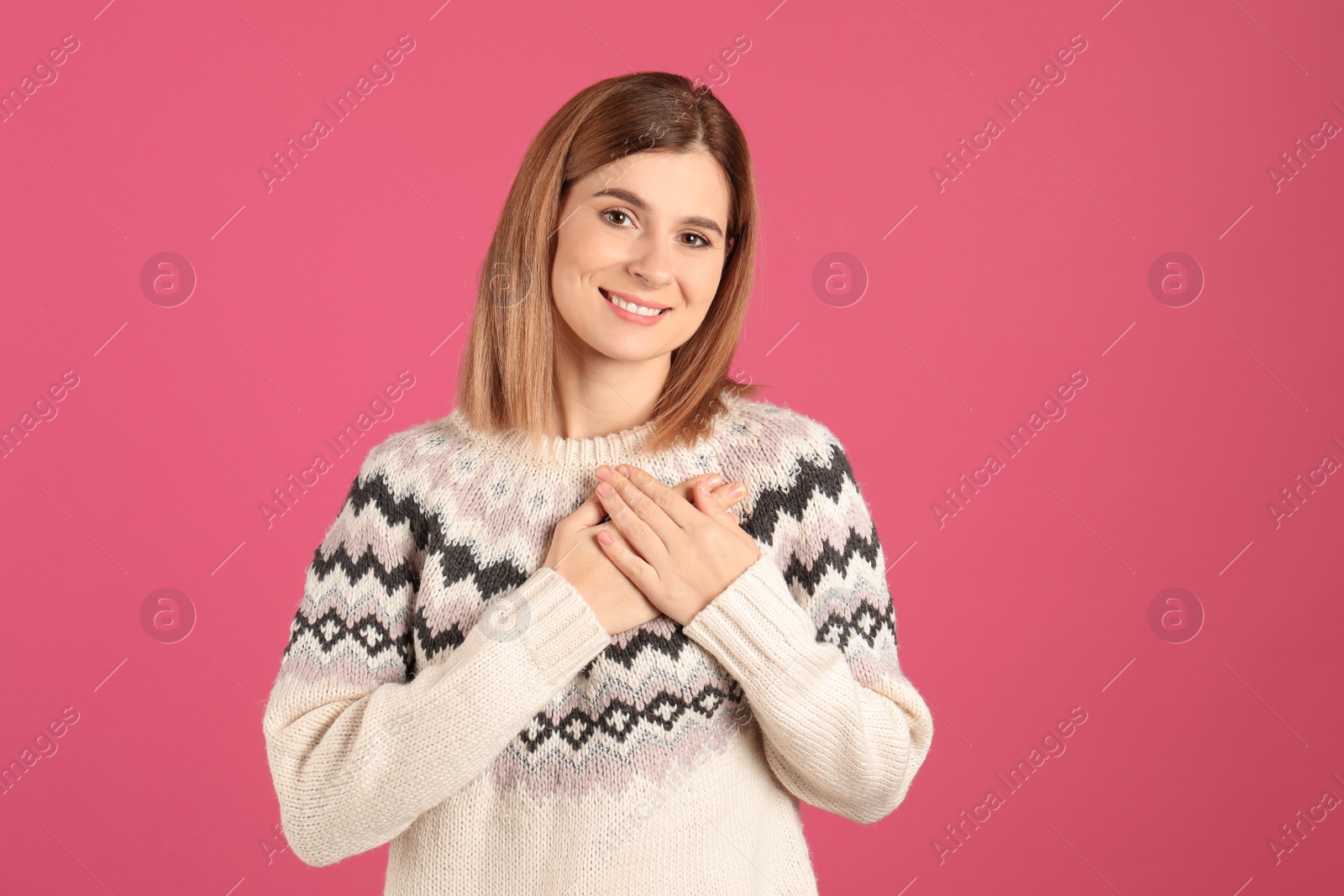 Photo of Portrait of woman holding hands near heart on color background