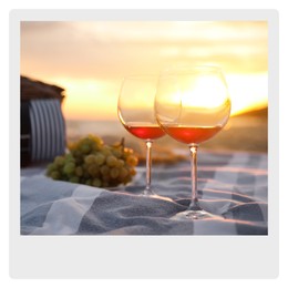 Paper photo. Blanket with glasses of wine and food on beach at sunset 