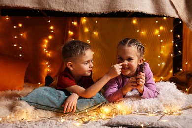 Photo of Happy kids playing in decorated play tent at home