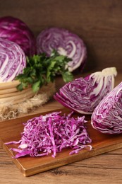 Photo of Cut fresh red cabbage on wooden table