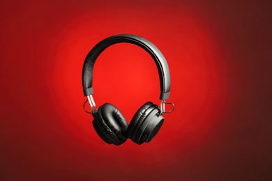 Photo of Stylish headphones with pads on color background