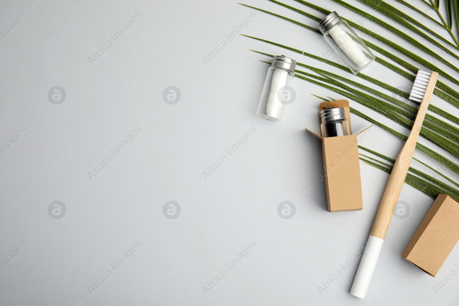 Photo of Flat lay composition with natural dental floss on light grey background. Space for text