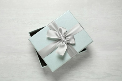 Photo of Beautiful gift box with bow on white table, top view