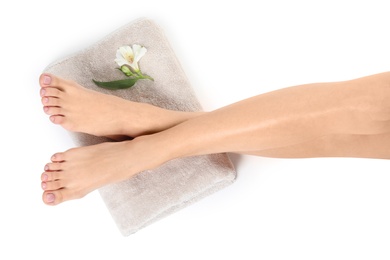 Woman with smooth feet, flower and towel on white background, top view. Spa treatment