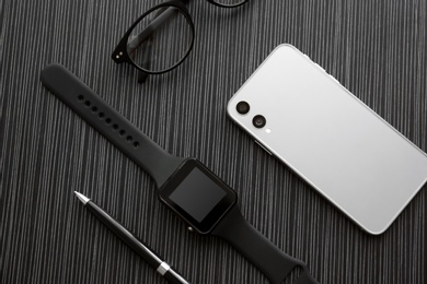 Photo of Flat lay composition with stylish smart watch on black table