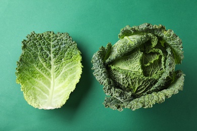 Photo of Fresh savoy cabbage on green background, flat lay