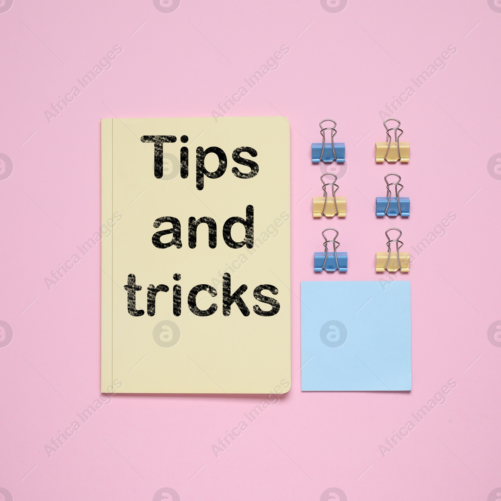 Image of Notebook with text Tips and tricks on pink background, flat lay