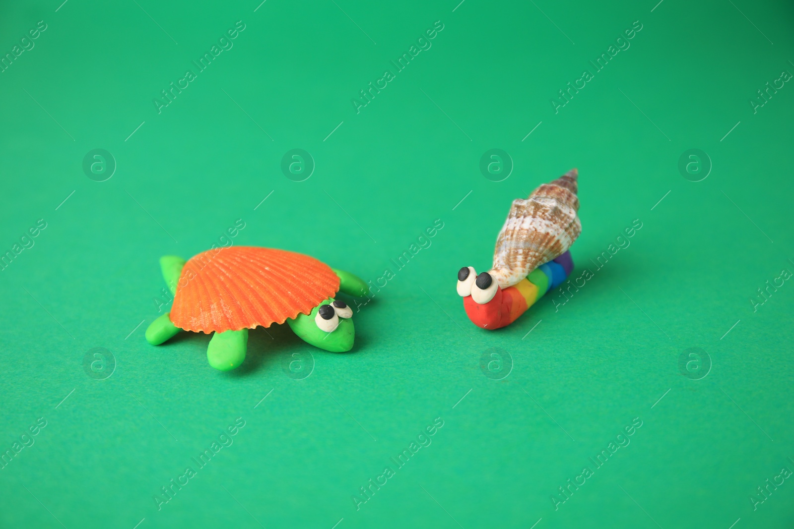 Photo of Turtle and snail made from plasticine on green background. Children's handmade ideas