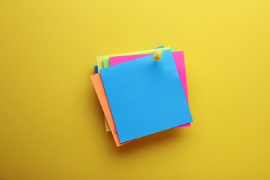 Photo of Paper notes on yellow background, top view