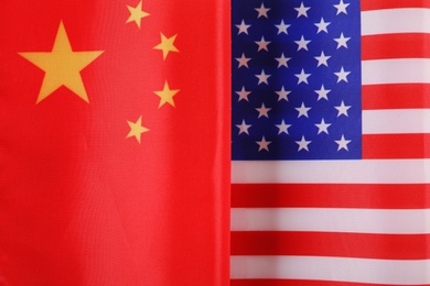 USA and China flags as background, top view. International relations