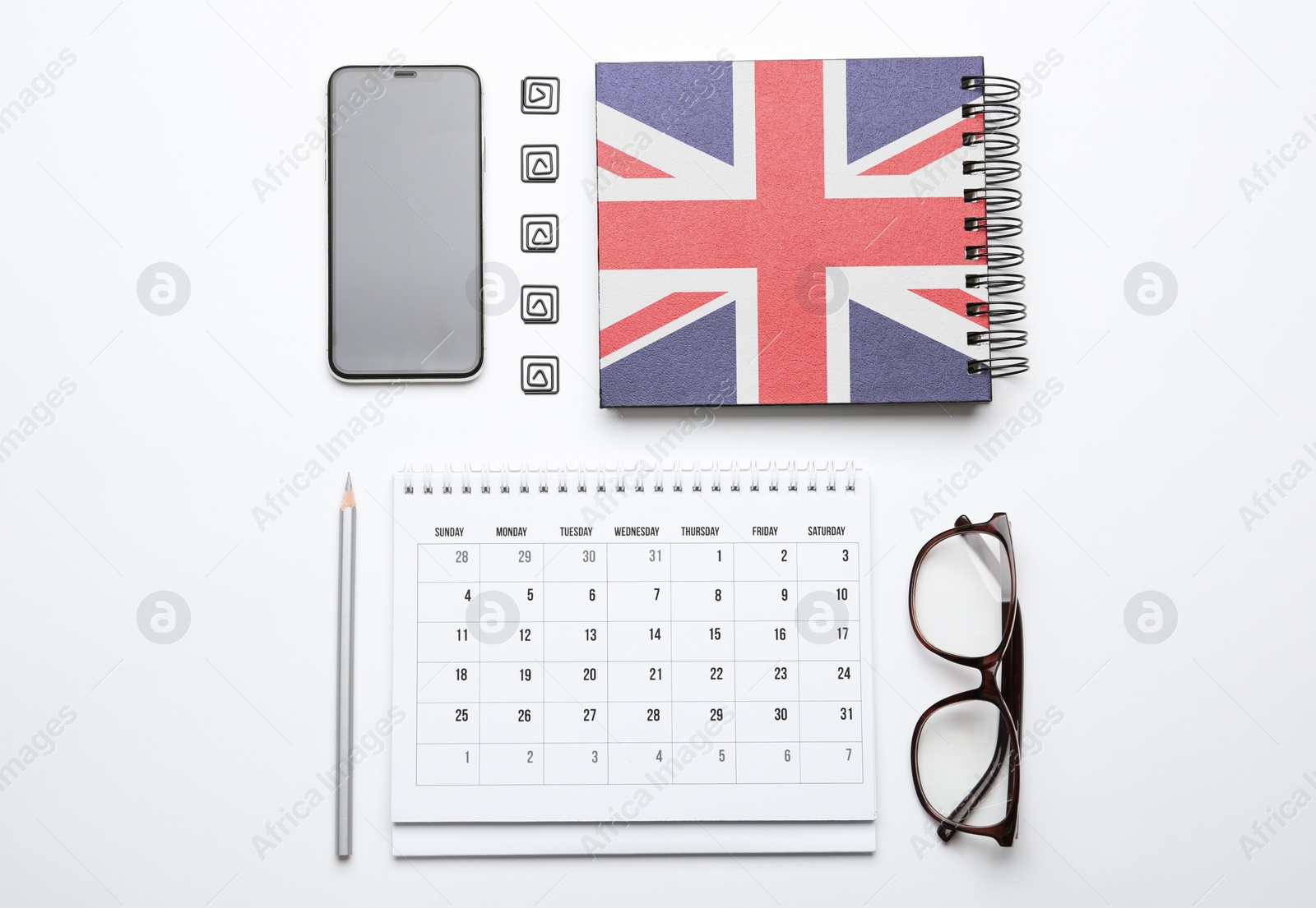 Image of Calendar, notebook, glasses and mobile phone on white background, top view. Learning English