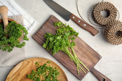 Flat lay composition with fresh green parsley on grey background