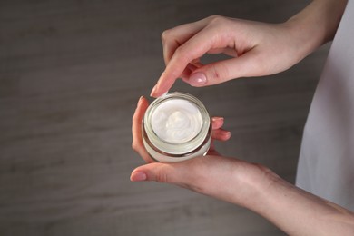 Photo of Woman applying hand cream indoors, above view