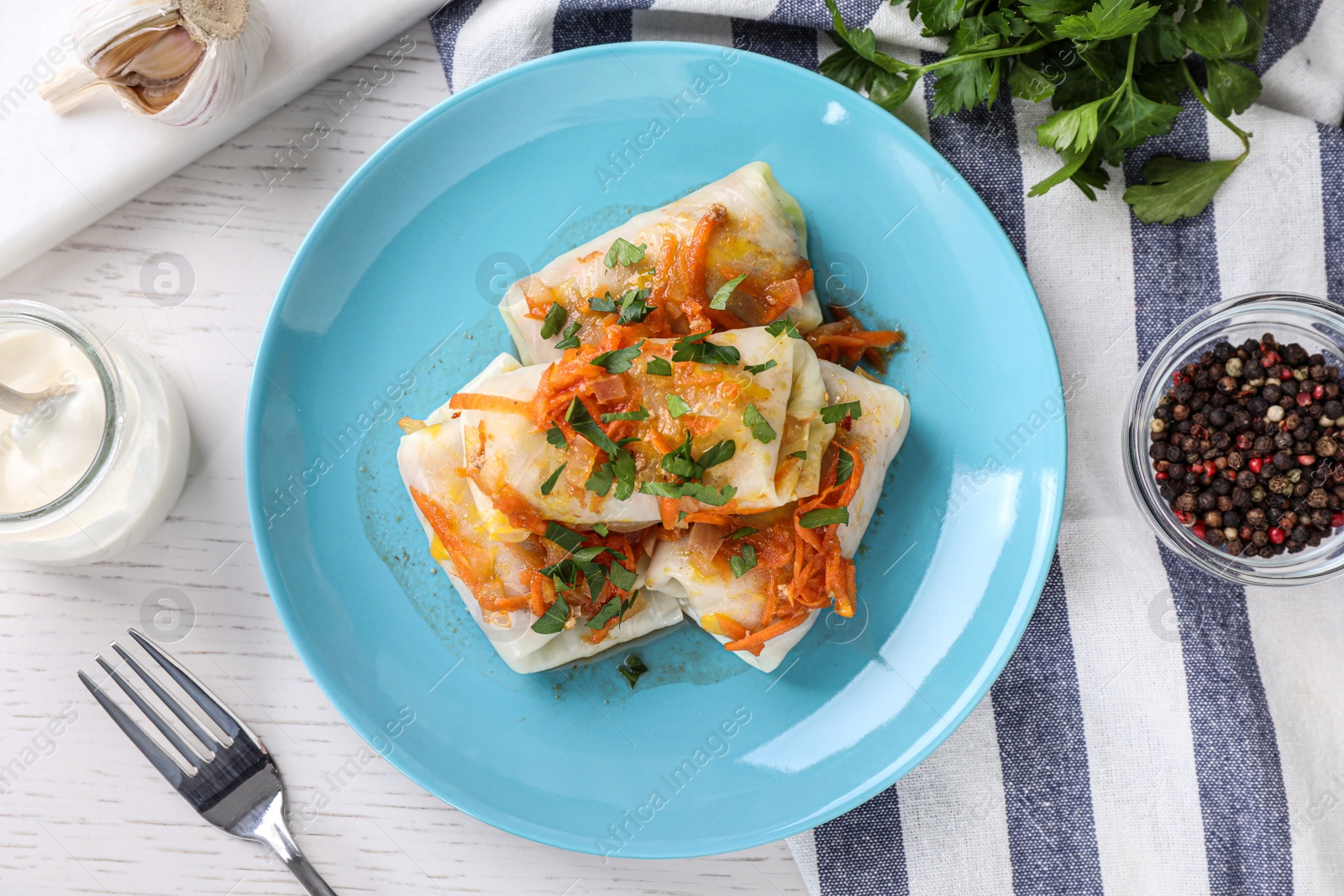 Photo of Delicious cabbage rolls served on white wooden table, flat lay