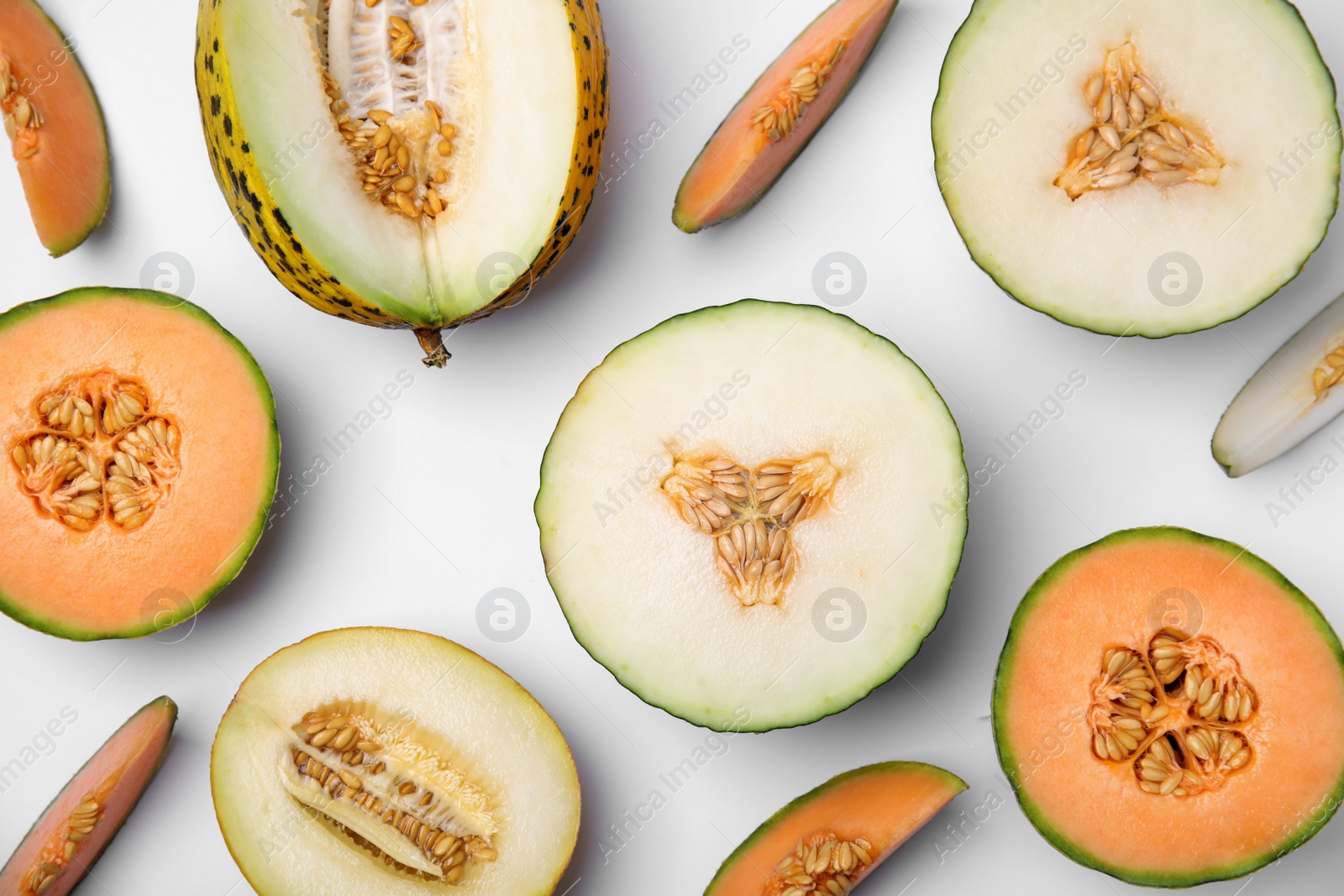 Photo of Cut different types of melons on white background, flat lay