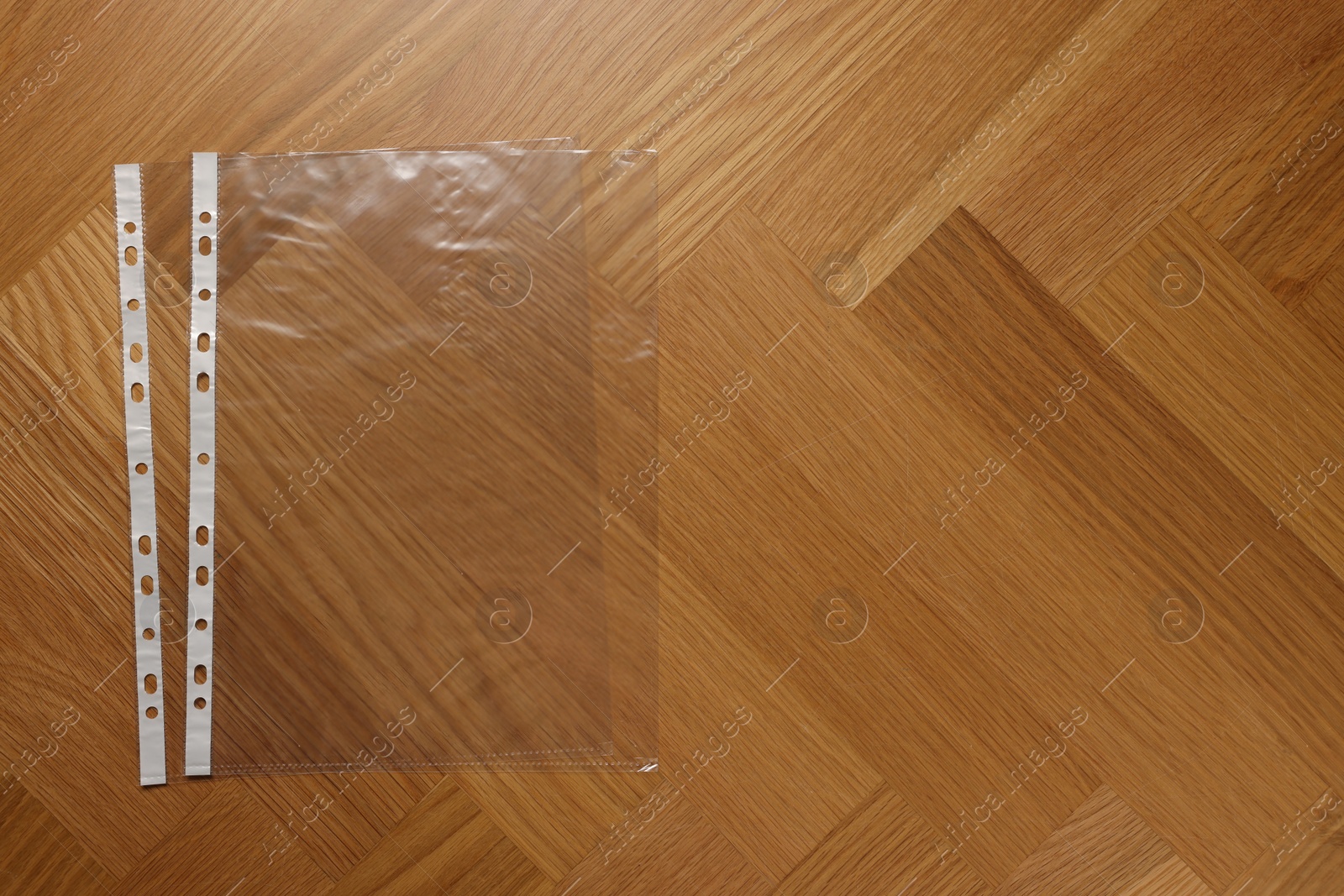 Photo of Punched pockets on wooden table, flat lay. Space for text