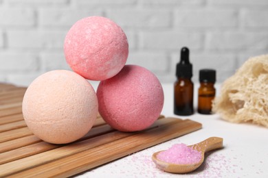 Photo of Beautiful composition with aromatic bath bombs on white table, closeup