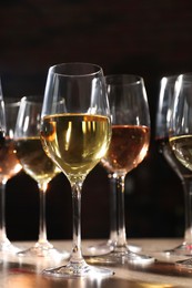 Photo of Different tasty wines in glasses on table