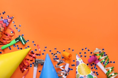 Photo of Flat lay composition with accessories for birthday party on orange background. Space for text