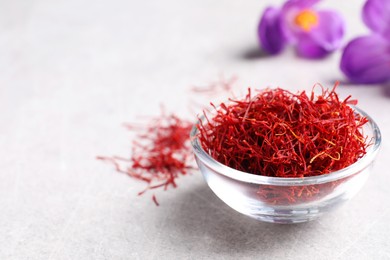 Photo of Dried saffron and crocus flowers on grey table, closeup. Space for text