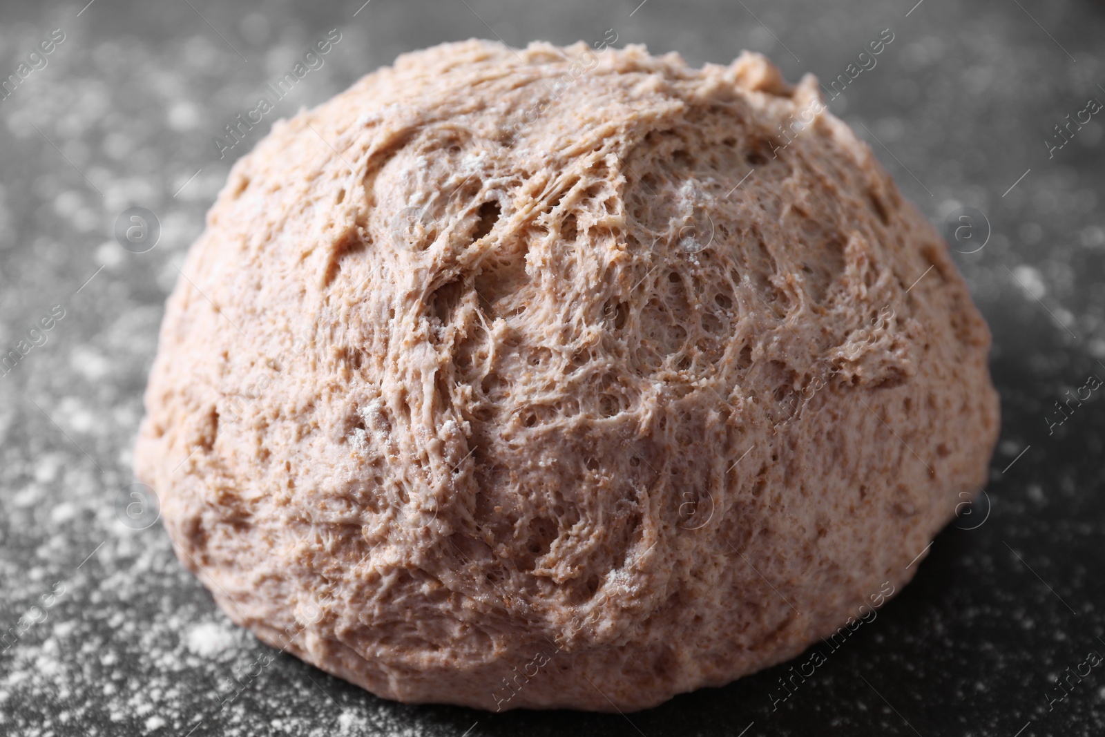 Photo of Fresh sourdough and flour on grey table, closeup