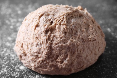 Fresh sourdough and flour on grey table, closeup