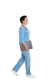 Full length portrait of female doctor in scrubs with clipboard isolated on white. Medical staff