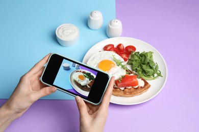 Photo of Woman taking photo of delicious breakfast on color background, closeup