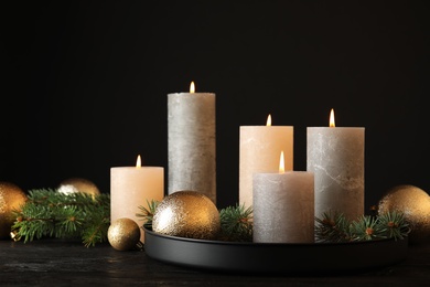 Burning candles with Christmas decoration on table