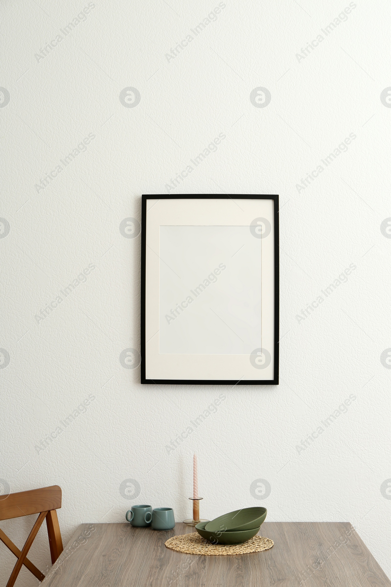 Photo of Room interior with dining table, wooden chairs and photo frame