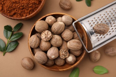 Flat lay composition with nutmegs on light brown background