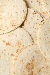 Many tasty homemade tortillas as background, top view