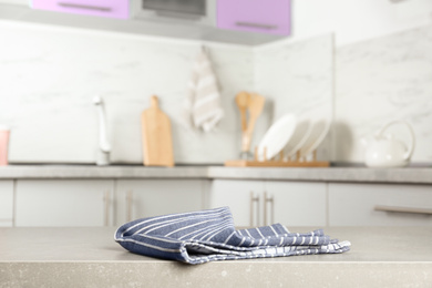 Photo of Striped cotton towel on light grey table in kitchen