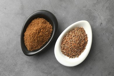 Caraway (Persian cumin) powder and dry seeds on gray table, top view