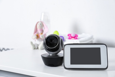 Photo of Baby monitor with camera and accessories on table against white background. Video nanny