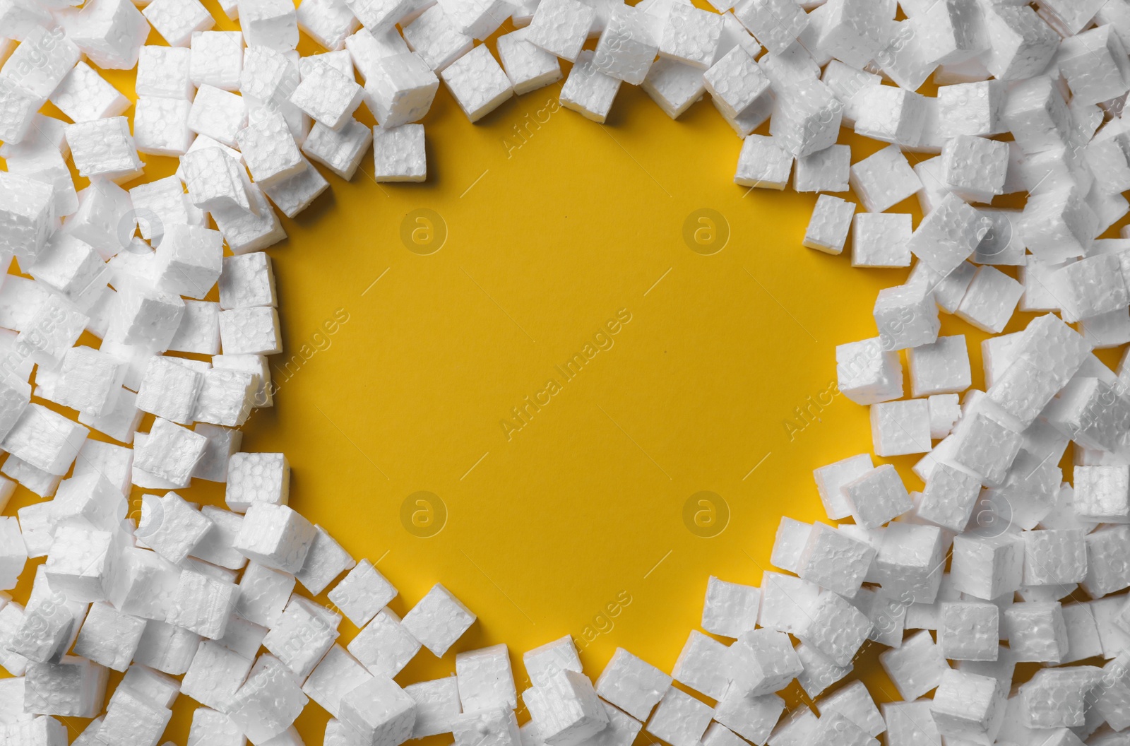 Photo of Frame made of styrofoam cubes on yellow background, flat lay. Space for text