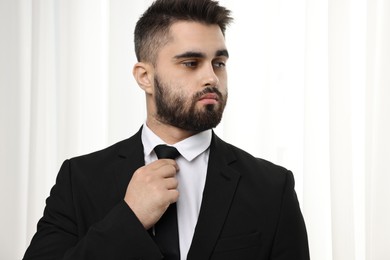 Handsome businessman in suit and necktie indoors