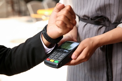 Photo of Man making payment with smart watch outdoors, closeup