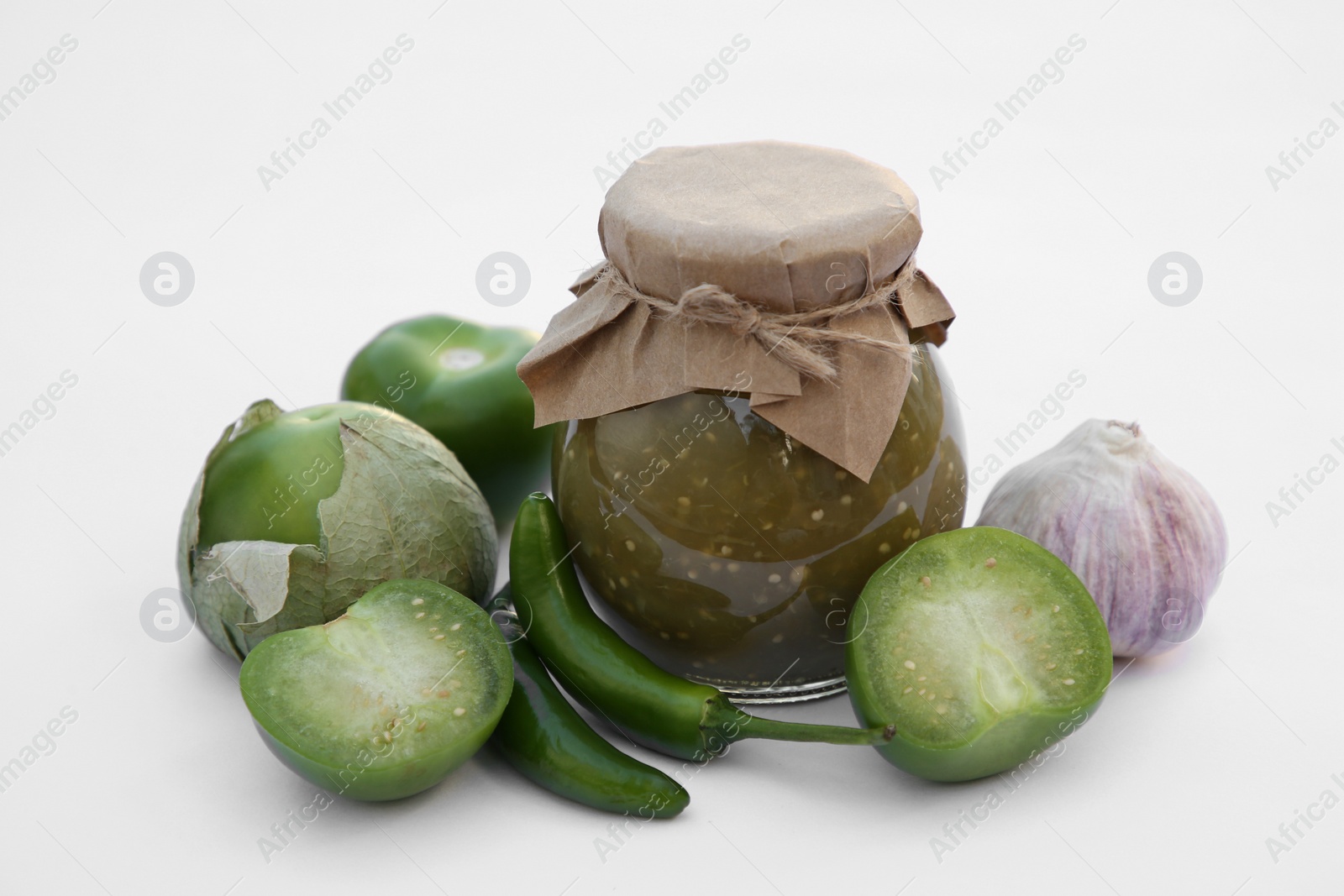 Photo of Jar with delicious salsa sauce and ingredients on white background